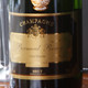 A close-up of a bottle of Champagne labeled "Bernard Remy Carte Blanche," featuring a black and gold design. The word "BRUT" is prominently displayed on the label, indicating the style of the Champagne. In the background, there are partially visible glassware, suggesting an elegant setting for serving the beverage. A close-up of a bottle of Champagne labeled "Bernard Remy Carte Blanche," featuring a black and gold design. The word "BRUT" is prominently displayed on the label, indicating the style of the Champagne. In the background, there are partially visible glassware, suggesting an elegant setting for serving the beverage.